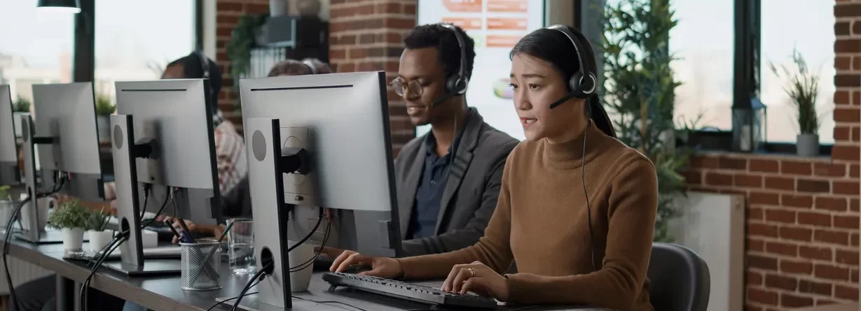 multiethnic-team-people-working-call-center-office-using-audio-headset-telecommunications-help-clients-people-answering-call-phone-helpline-giving-assistance-workstation_